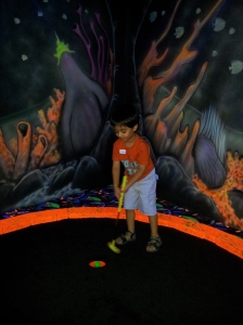 Nadir trying a round of mini-golf
